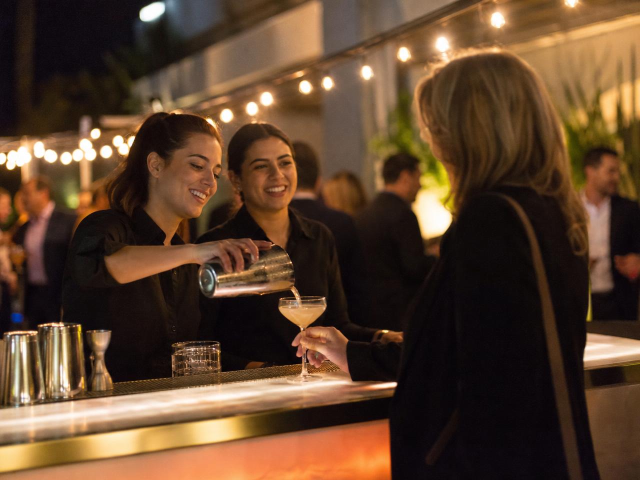 A premium brand activation at night with a lit bar and ambassadors